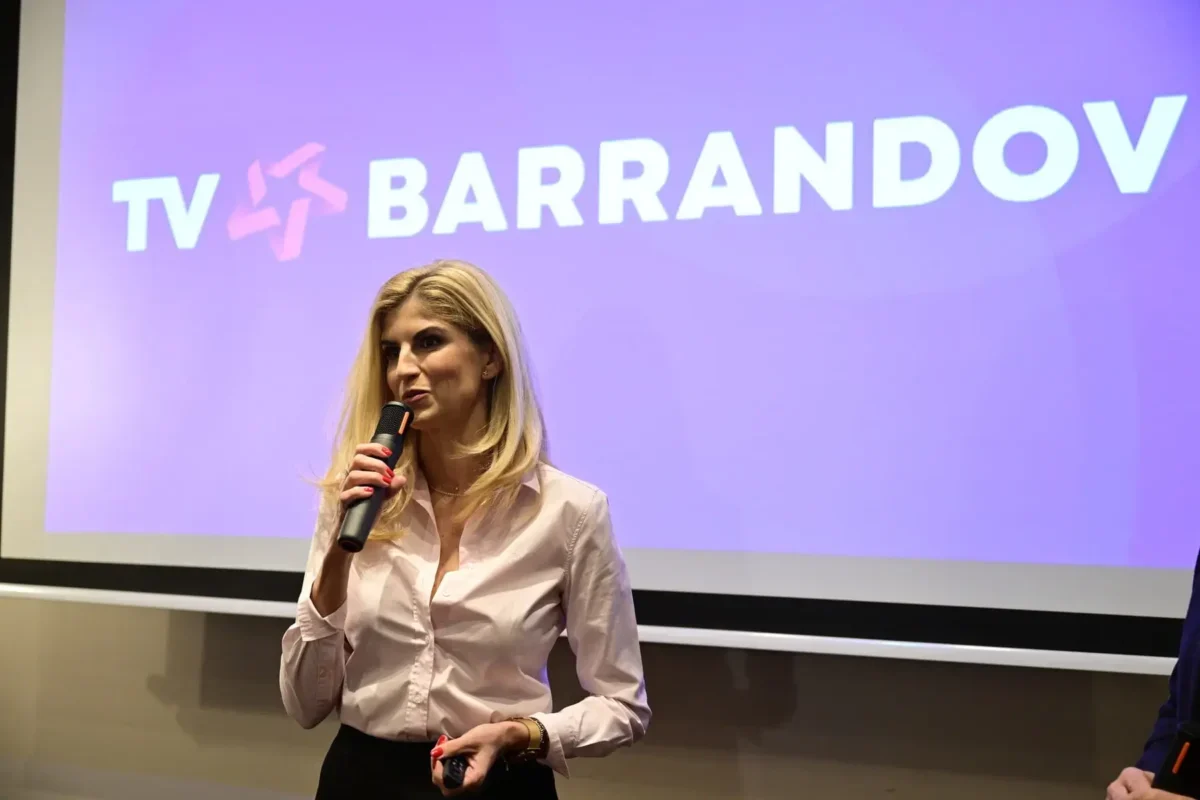 žena s mikrofonem stojí před plátnem