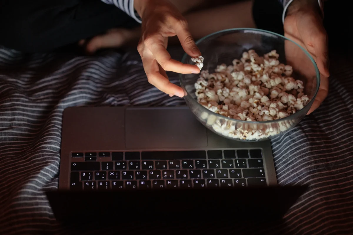 Člověk z misky ujídá popcorn. 