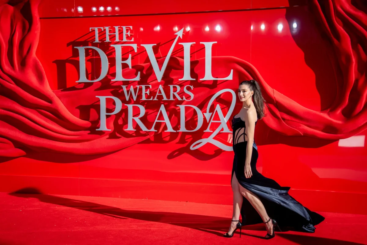 Anne Hathaway kráčí před nápisem Devil wears Prada 2.