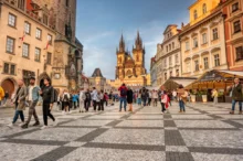 Turisté chodí po Praze.