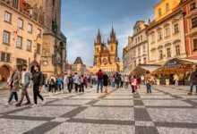 Turisté chodí po Praze.