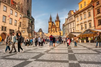 Turisté chodí po Praze.