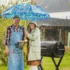 Dva lidé stojí na zahradě u grilu v dešti pod deštníkem