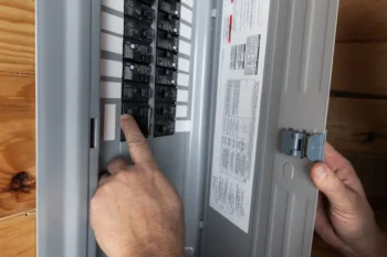 Muž kontroluje elektrické jističe.