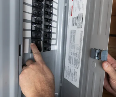 Muž kontroluje elektrické jističe.