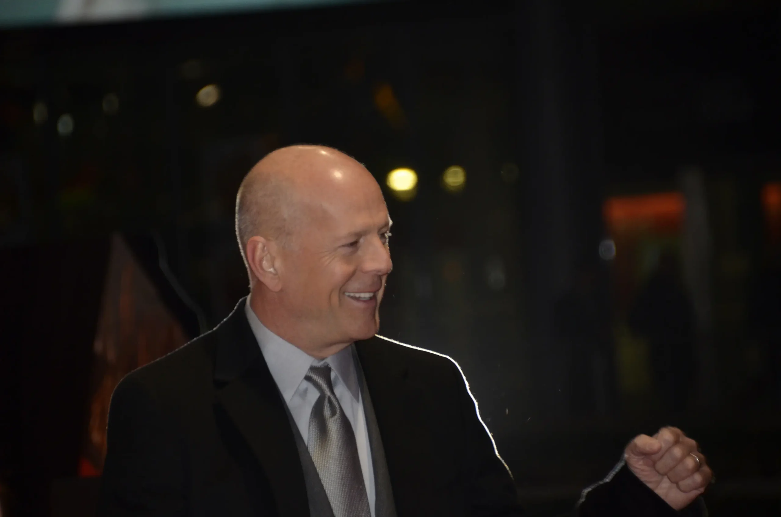 Bruce Willis se usmívá.