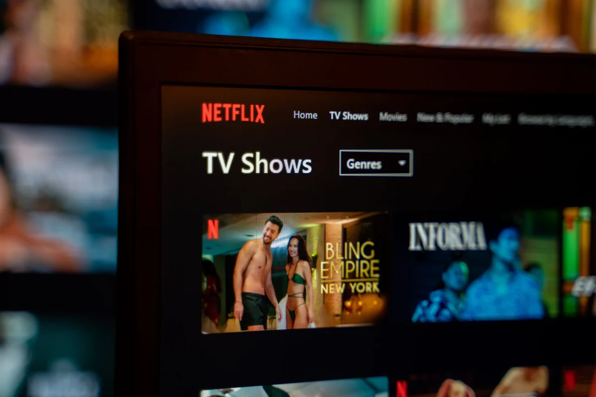 shutterstock_2294725691 1 | TVGURU.cz Netflix streaming interface on a screen showing 'TV Shows' with a 'Genres' button and posters beneath