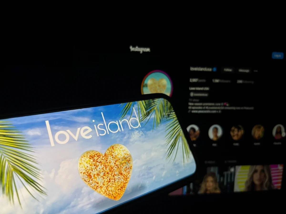 shutterstock_2637692919 1 | TVGURU.cz HD monitor displaying the 'Love Island USA' promo with a tropical beach background and palm leaves.