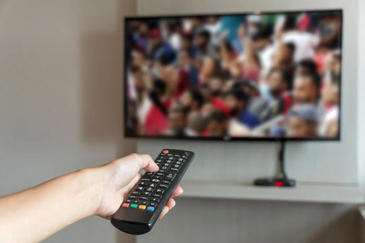 shutterstock_2236697337-2 | TVGURU.cz Člověk ovladačem míří na televizi.