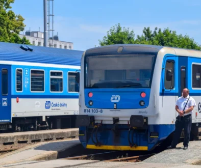 průvodčí stojící vedle vlaku