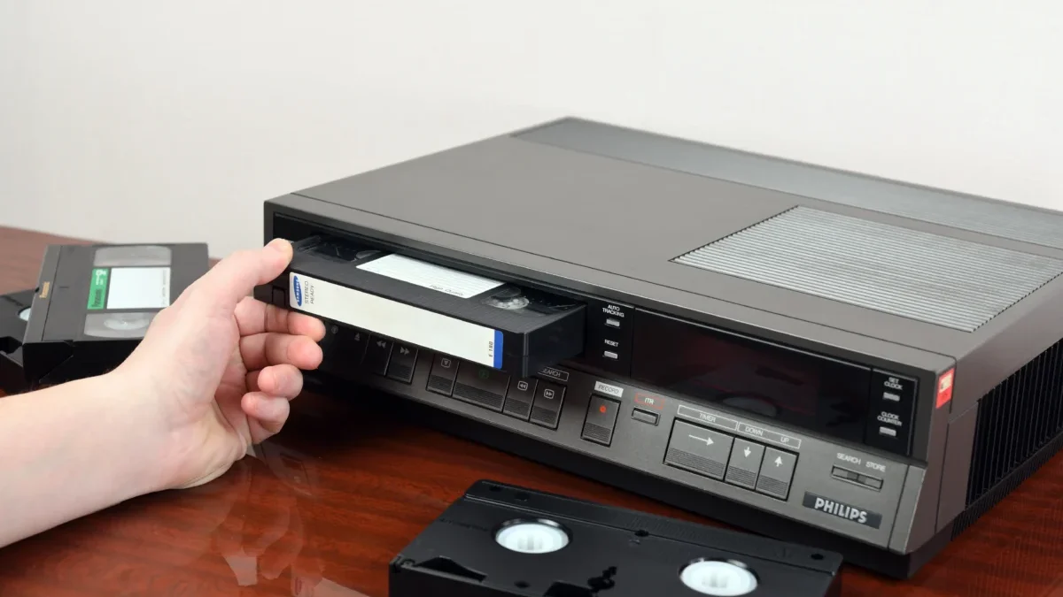 Člověk zastrkává VHS kazetu.