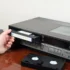 Člověk zastrkává VHS kazetu.