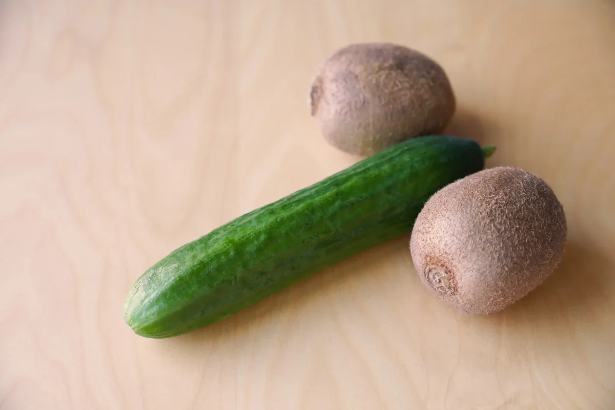 shutterstock_2606839273-2 | TVGURU.cz Okurka leží mezi dvěma kusy kiwi.