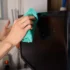 Člověk hadříkem otírá televizi.