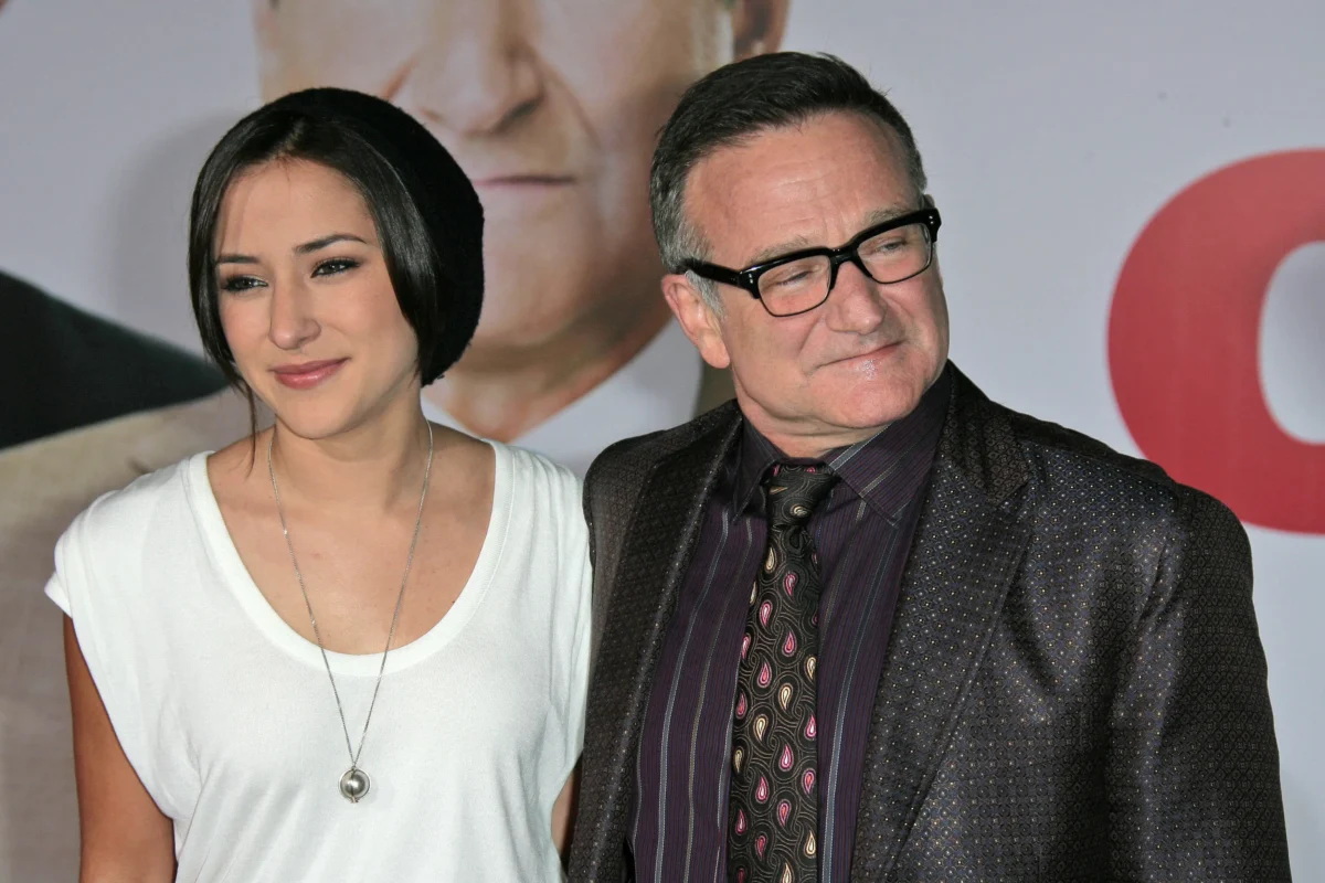 shutterstock_104224703 1 | TVGURU.cz Two adults posing for a photo at an event: a woman in a white top with dark hair and a man in a dark patterned suit with glasses.