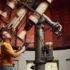 Astronom stojí u velkého teleskopu