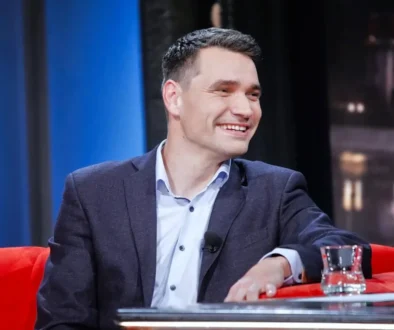 Moderátor Daniel Stach sedí na gauči.