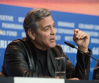 George Clooney mluví do mikrofonu.
