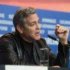 George Clooney mluví do mikrofonu.