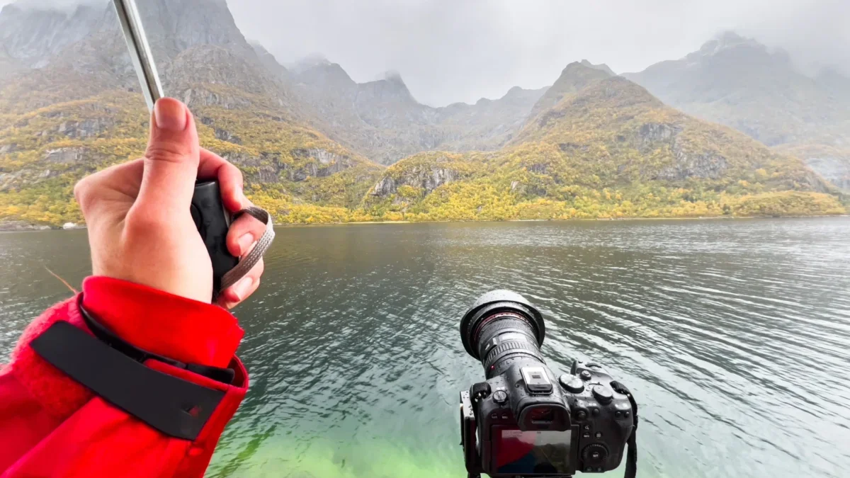 Fotograf v dešti s fotoaparátem u jezera