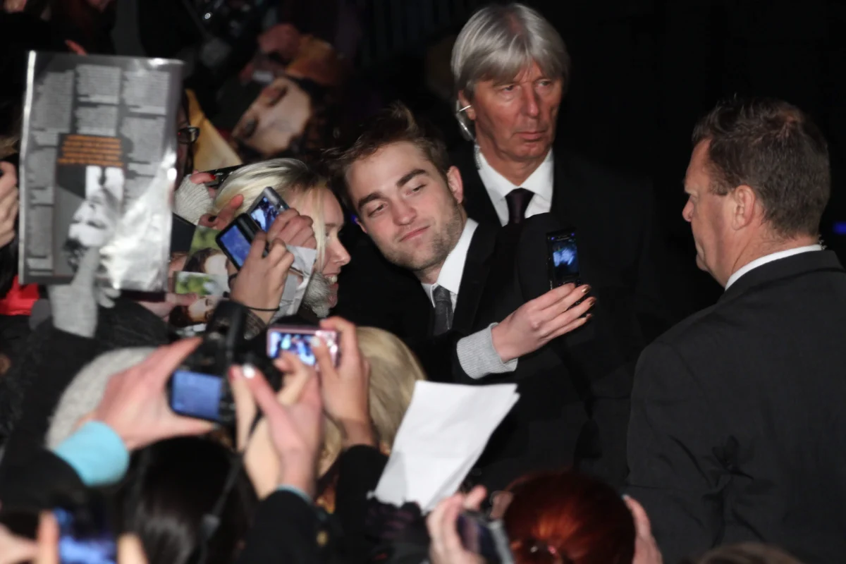 Robert Pattinson je schovaný mezi novináři.