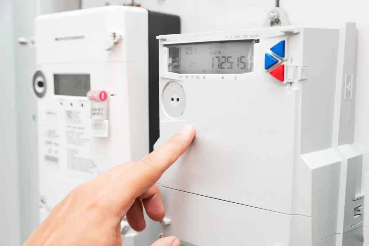Shutterstock_2482089129 | TVGURU.cz Člověk prstem ukazuje na elektroměr.