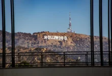 Hollywood sign on a hill seen through a window with black vertical bars in the foreground.