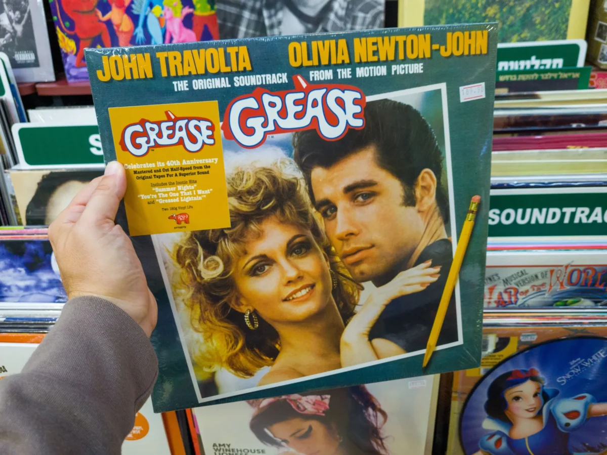 133 Vinylový obal originálního soundtracku k filmu Pomáda, na kterém jsou John Travolta a Olivia Newton-John drženi v obchodě s dalšími deskami poblíž.
