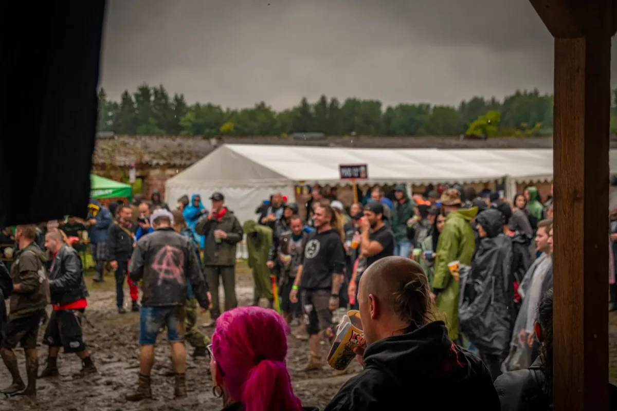 lidé na festivalu stojí na dešti