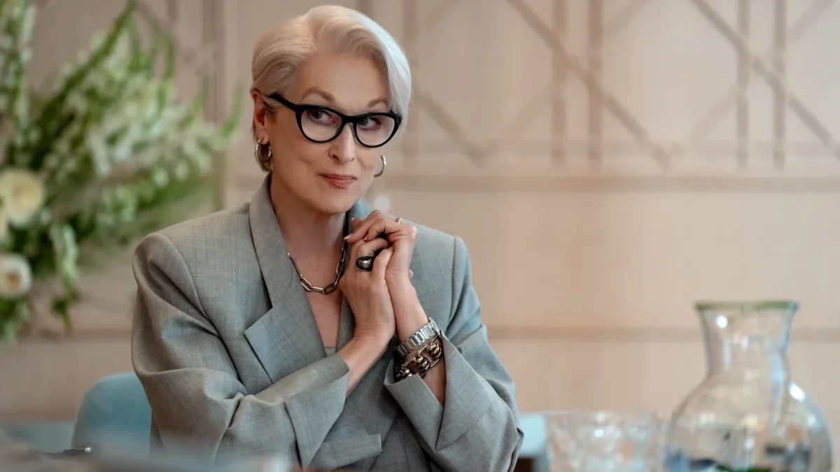 Meryl Streep sedí u stolu.