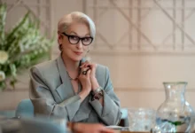Meryl Streep sedí u stolu.