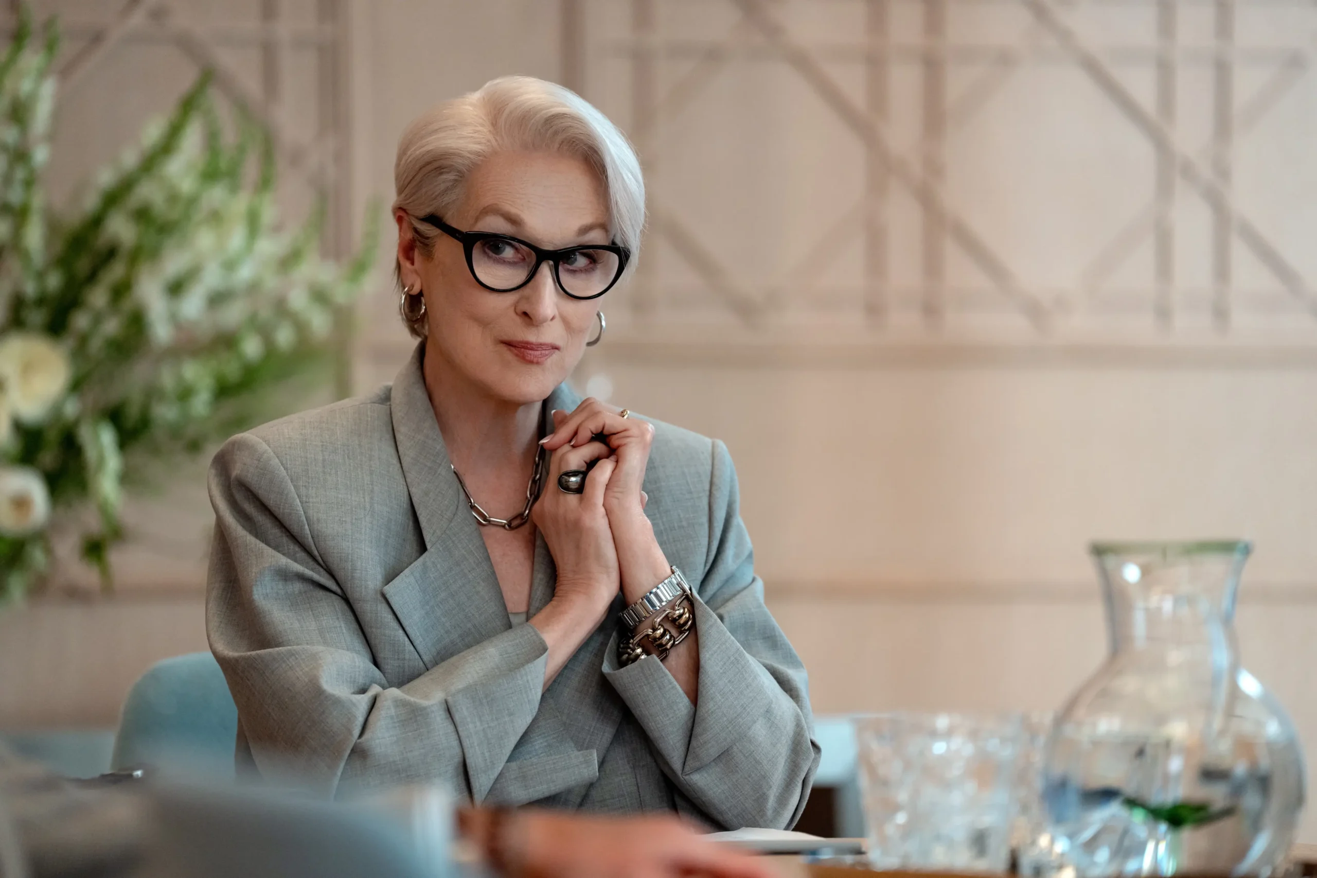 Meryl Streep sedí u stolu.