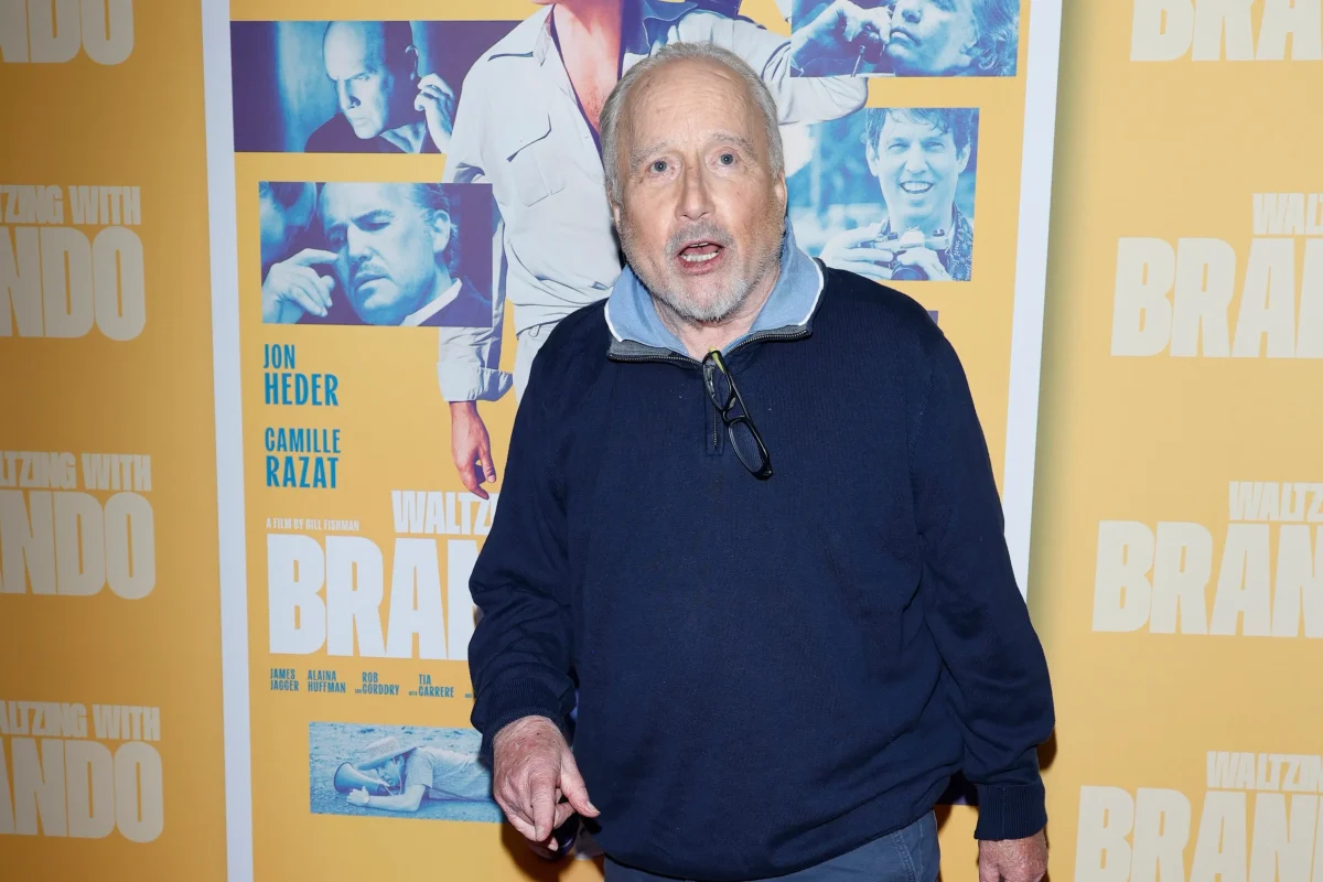 Richard Dreyfuss stojí u zdi.
