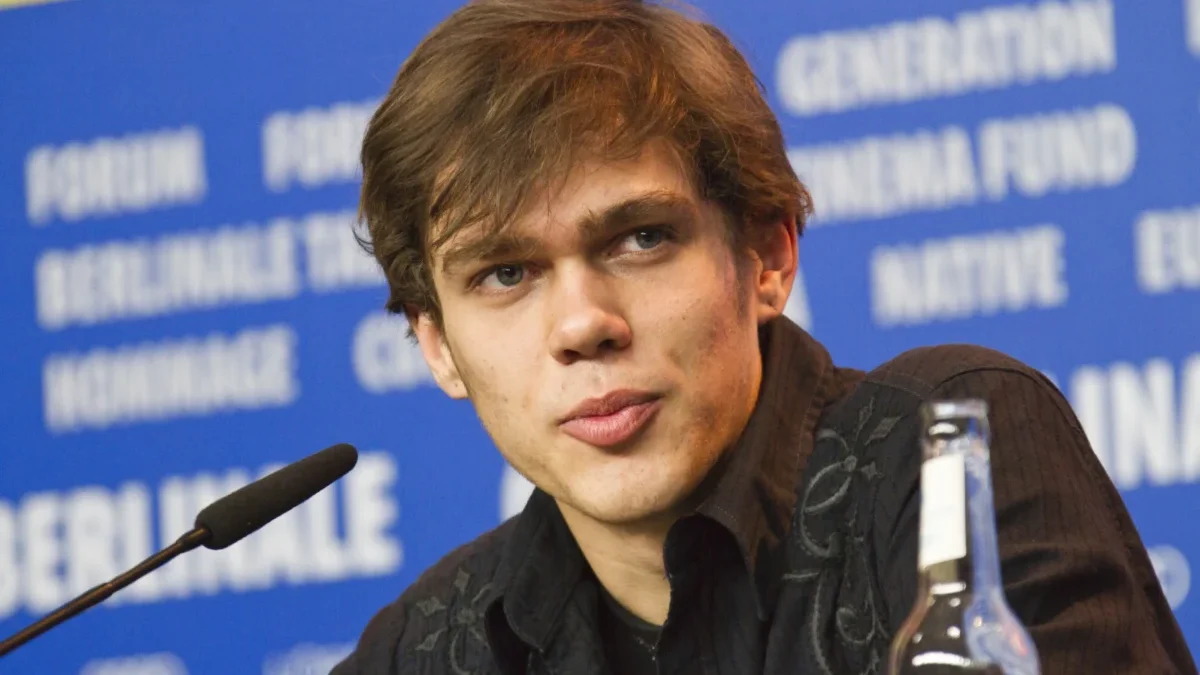 Ellar Coltrane sedí u mikrofonu.
