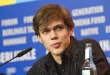 Ellar Coltrane sedí u mikrofonu.