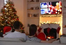 Rodina sedí u vánočního stromku a televizoru