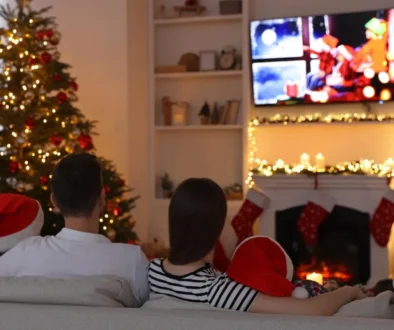 Rodina sedí u vánočního stromku a televizoru