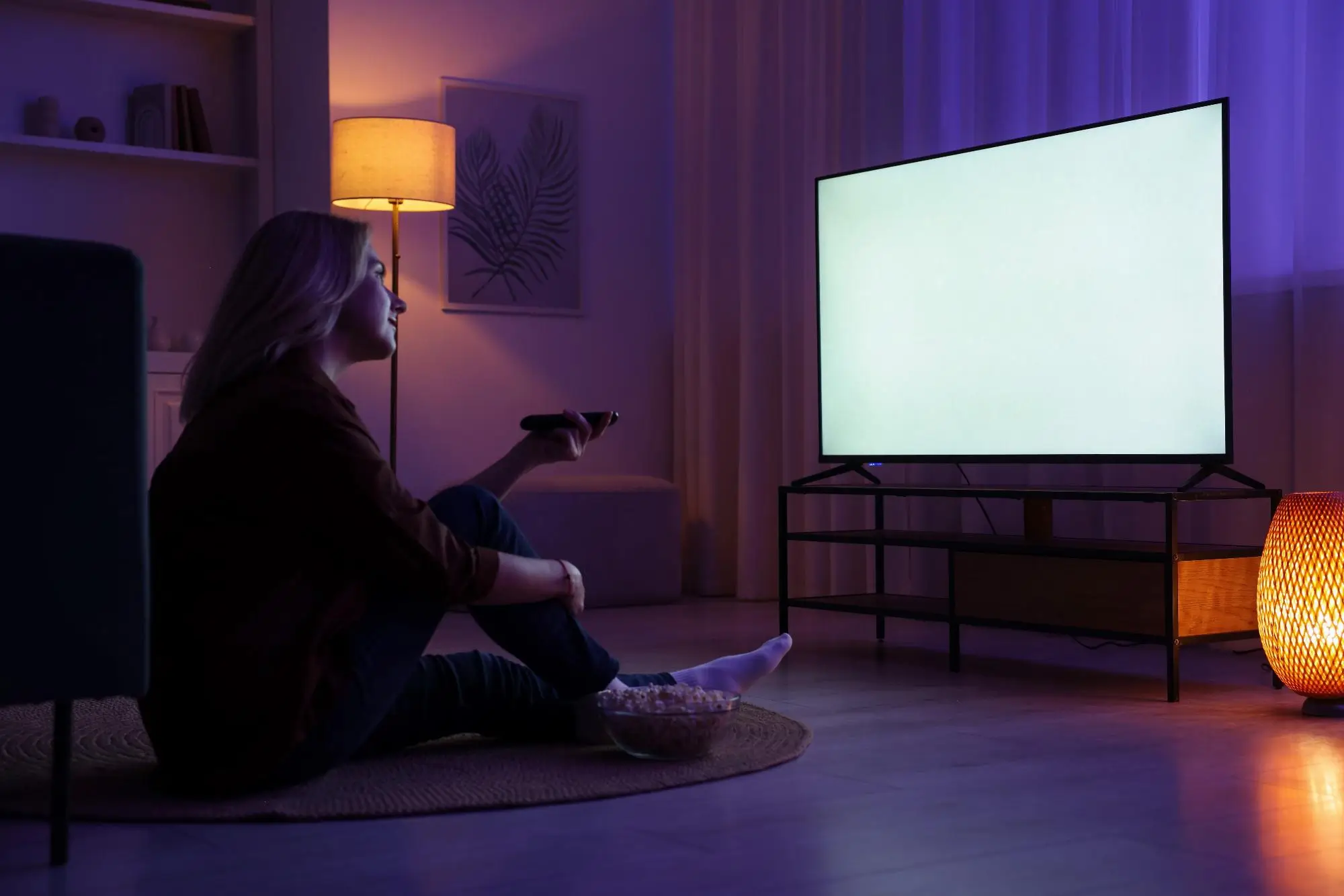Komu udělá nový kanál TV Prima radost? | TVGURU.cz Žena sedí před televizí.