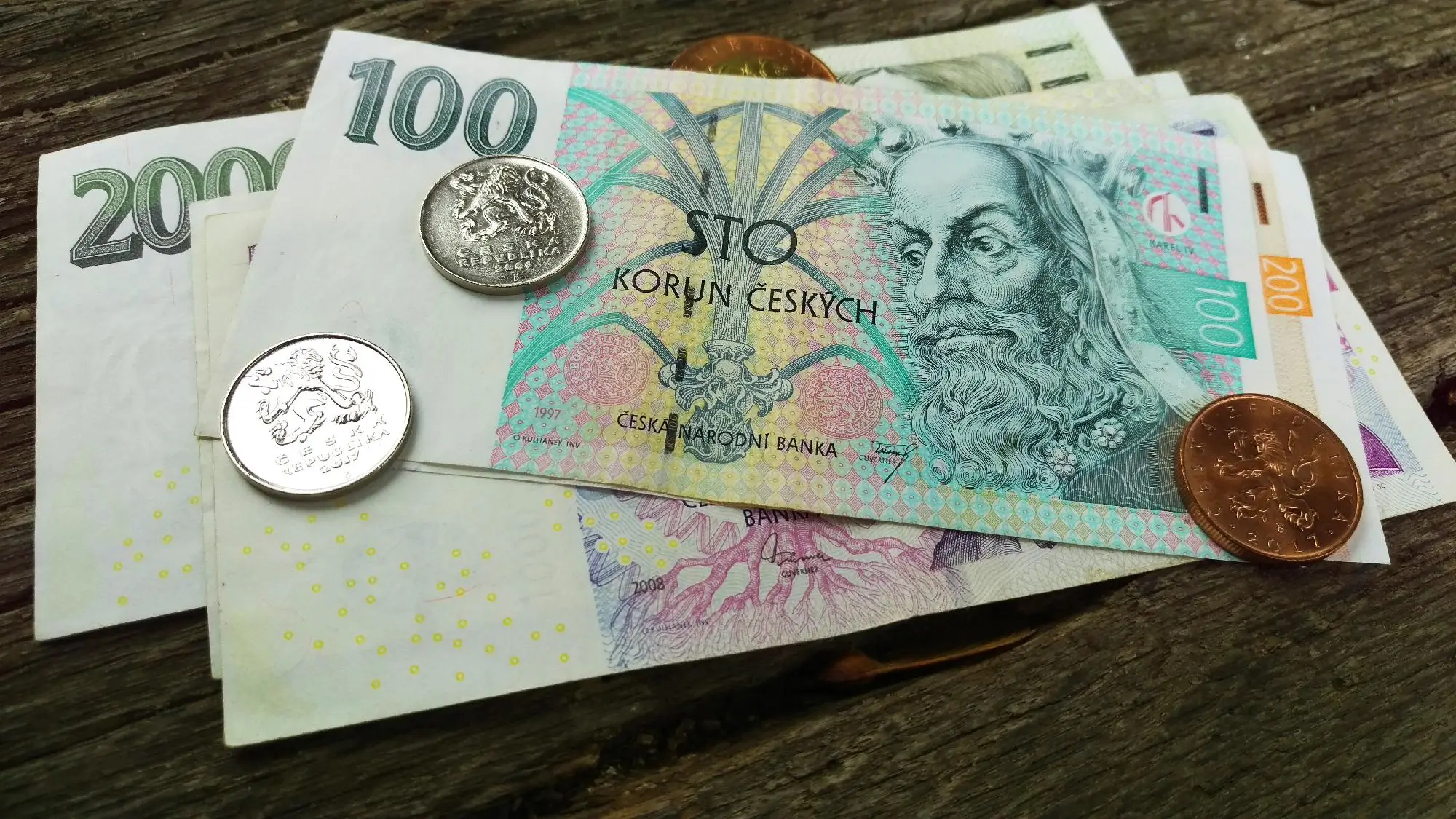 Na stole leží české bankovky.