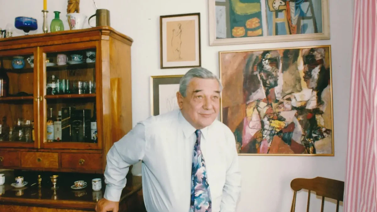 Josef Vinklář stojí u skříně.