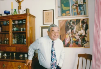 Josef Vinklář stojí u skříně.