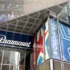 Glass-fronted building with large blue banners reading 'Paramount' along the windows and a metal, paneled overhang above the entrance showing a colorful mural.