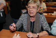 Jaroslava Obermaierová sedí u stolu.