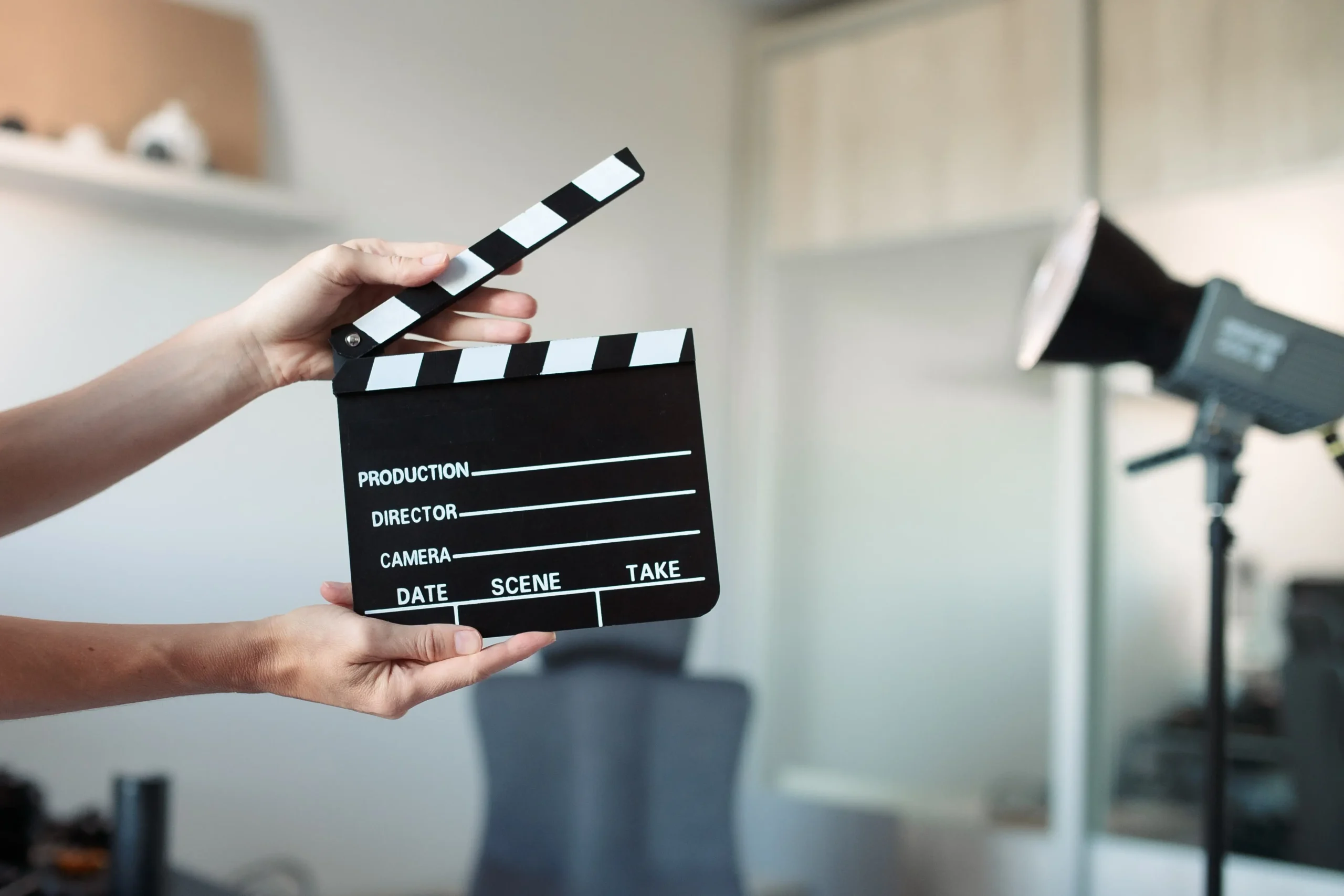 natáčení | TVGURU.cz Člověk v ruce drží filmovou klapku.