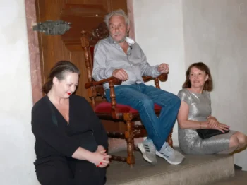 Jan Saudek sedí na židli mezi dvěma ženami.