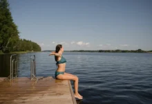 Žena sedí na okraji mola.