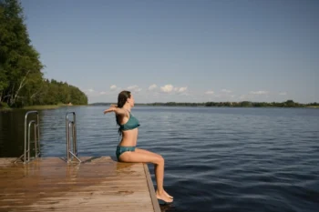 Žena sedí na okraji mola.