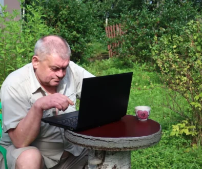 Senior sedí u notebooku.