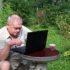 Senior sedí u notebooku.