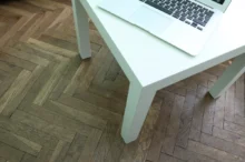 Na parketách stojí stolek.